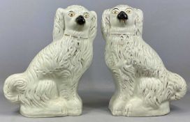 PAIR OF LARGE 19TH CENTURY SEATED SPANIELS, cream glazed with moulded and gilded 'fur', 39cms (h)