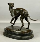 20TH CENTURY BRONZE SCULPTURE OF A STANDING GREYHOUND, head over shoulder, on oval black base, 27cms