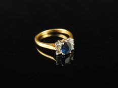 SAPPHIRE & DIAMOND RING, centred with an oval-cut sapphire, approx. 0.5ct, flanked by four small