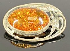 OVAL AMBER BROOCH with naturalistic silver openwork mount, 35 x 25mms Provenance: private collection