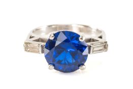 SYNTHETIC BLUE SPINEL & DIAMOND RING, principal stone 10mm (diam.), flanked by 2 baguette cut