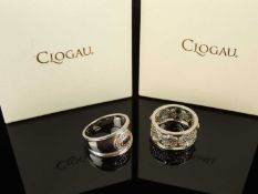 TWO CLOGAU SILVER DRESS RINGS, one centred with an oval-cut sapphire, bordered with tiny diamonds,