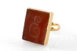 YELLOW METAL INTAGLIO CARNELIAN RING, engraved with letter 'E', ring size H, 10.4g Provenance:
