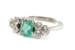 EMERALD & DIAMOND RING, principal emerald-cut emerald 7 x 5.5mms, between triple clusters of old