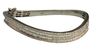 18CT WHITE GOLD DIAMOND BANGLE, two rows of small baguettes flanked by a line of tiny brilliants