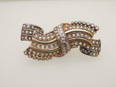 CONTINENTAL ROSE DIAMOND RIBBON BROOCH, c. 1900, centred with an old cushion cut stone, approx. 0.