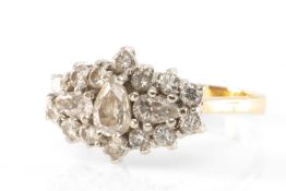 18CT GOLD DIAMOND CLUSTER RING, comprising three central pear cut diamonds within a border of