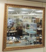 LARGE MODERN MOULDED GILT FRAMED BEVELLED GLASS WALL MIRROR, 143cm square Provenance: Private