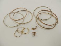 FOUR UNMARKED GOLD-COLOURED BANGLES, two similar silver-coloured bangles, four gold-coloured