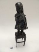 BRONZE FIGURE OF A COY CHILD, standing on a stool, 29cms (h) Provenance: private collection