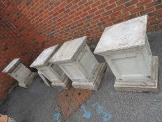 FOUR RECONSTITUTED STONE GARDEN PLINTHS, each 70cms (h), with 48cms² top, and a spare plinth base