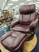MAROON LEATHER UPHOLSTERED SWIVEL ARMCHAIR and matching footstool Provenance: private collection