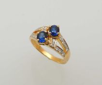SAPPHIRE & DIAMOND SPLIT-SHANK RING, set with two small oval-cut sapphires, bordered with small