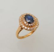 18CT GOLD SAPPHIRE & DIAMOND CLUSTER RING, oval-cut sapphire approx. 1ct, bordered with two rows