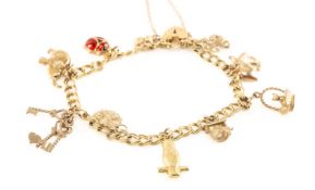 9CT GOLD CHARM BRACELET, double wire curb links with 10 charms and padlock clasp, 12.3gms