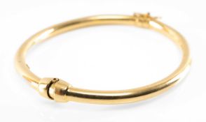 18CT GOLD SPRING HINGED BANGLE, plain design, stamped '750', safety clasp, 10.9gms Provenance:
