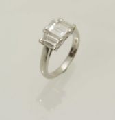 DIAMOND THREE-STONE RING, centred with an emerald cut diamond, approx. 1ct, and flanked by smaller