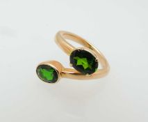 GREEN TOURMALINE TWO-STONE CROSSOVER RING, oval cut stones approx. 7 x 5mms, one in a collet