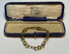 9CT GOLD PERIDOT & PEARL BRACELET, open scrollwork, set with four oval-cut peridots, each of approx.