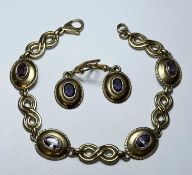 AMETHYST BRACELET in unmarked yellow metal, set with four oval-cut stones within polished mounts,