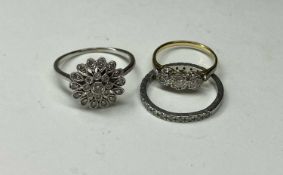 THREE DIAMOND RINGS, including a three-stone ring with illusion set brilliant diamonds, total