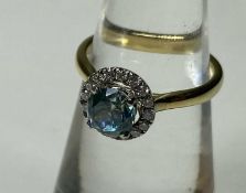 BLUE ZIRCON & DIAMOND HALO CLUSTER RING, central zircon approx. 0.75cts, bordered with tiny