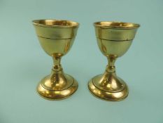 PAIR OF GEORGIAN BRASS EGG CUPS, on spreading circular bases, 8cms (h) Provenance: private