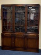 20TH CENTURY MAHOGANY CAMPAIGN TYPE LIBRARY BOOKCASE with brass mounts, the upper section with
