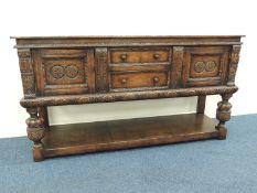 QUALITY JACOBEAN STYLE OAK DRESSER BASE, two central drawers, cupboard to either side with carved