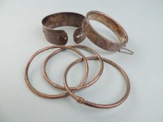 SILVER HOLLOW HINGED BANGLE, with scroll engraved decoration to one half and safety chain; hollow