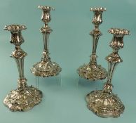 SET OF FOUR VICTORIAN EPNS CANDLESTICKS, of Rococo form, with detachable nozzles, 25.5cms (h)