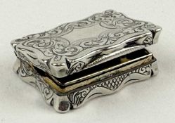 VICTORIAN SILVER VINAIGRETTE of rectangular form with shaped sides, scroll engraved decoration,