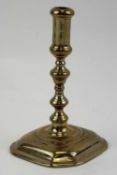QUEEN ANNE CAST BRASS SMALL CANDLESTICK with knopped stem, and shaped square moulded base, 11cms (h)