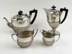 GEORGE V SILVER COMPOSITE TEA SERVICE with gadrooned decoration, teapot and hot water jug with ebony