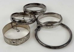 SILVER BANGLES, three oval hinged with engraved decoration and safety chains; circular 'slave', 9cms