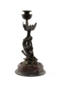 GRAND TOUR BRONZE CANDLESTICK, probably Naples c. 1900, modelled with Eros riding a dolphin on