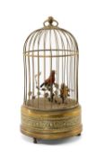 SINGING BIRD AUTOMATON, 20th C, in gilt metal cage, the red and yellow birds amid leafy vine,