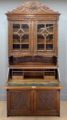 20TH C. FLEMISH STYLE CARVED OAK BUREAU BOOKCASE, fitted interior, tooled leather writing insert,