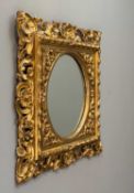 ANTIQUE FLORENTINE STYLE GILTWOOD MIRROR, cirular plate within elobarate rectangular frame with