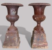 TWO LARGE CAST IRON CAMPANA GARDEN URNS, both raised on square section plinths, 110 & 112cms (h),