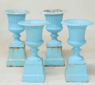 TWO PAIRS OF PAINTED CAST IRON GARDEN PEDESTAL URNS, each on stepped square plinths, tallest