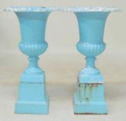 PAIR OF PAINTED CAST IRON GARDEN PEDESTAL URNS, each of campagna form, on a stepped square plinth,