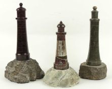 THREE CORNISH SERPENTINE LIGHTHOUSE SOUVENIR DESK ORNAMENTS, 30.5cms (h) the tallest, 24.5cms (h)
