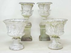 PAIR OF WEATHERED RECONSTITUTED STONE PEDESTAL GARDEN URNS, cast with figures (repairs), 99cms (