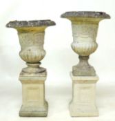 NEAR PAIR OF WEATHERED RECONSTITUTED STONE GARDEN PEDESTAL URNS, of campagna form, raised on a