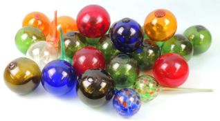 COLLECTION OF TWENTY-ONE COLOURED GLASS FISH FLOATS, also a large clear glass float, 32cm (d); and