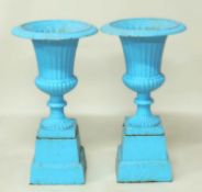 PAIR OF PAINTED CAST IRON GARDEN PEDESTAL URNS, with plinths, campagna shape with egg and dart
