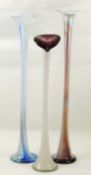 THREE DECORATIVE COLOURED GLASS FLOOR STANDING ORCHID / STEM VASES, tallest 102cms (h), smallest