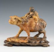 CHINESE CARVED SOAPSTONE 'BOY ON BUFFALO', 20th C, on naturalistic base and carved wood stand, 15cms