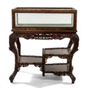 ANGLO-CHINESE CARVED HONGMU BIJOUTERIE TABLE CABINET ON STAND, glazed with fall front, on tiered
